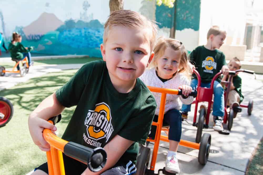 Ontario Christian Preschool students ride tricycles
