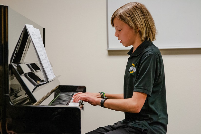 Middle school student playing piano at Fine Arts Festival