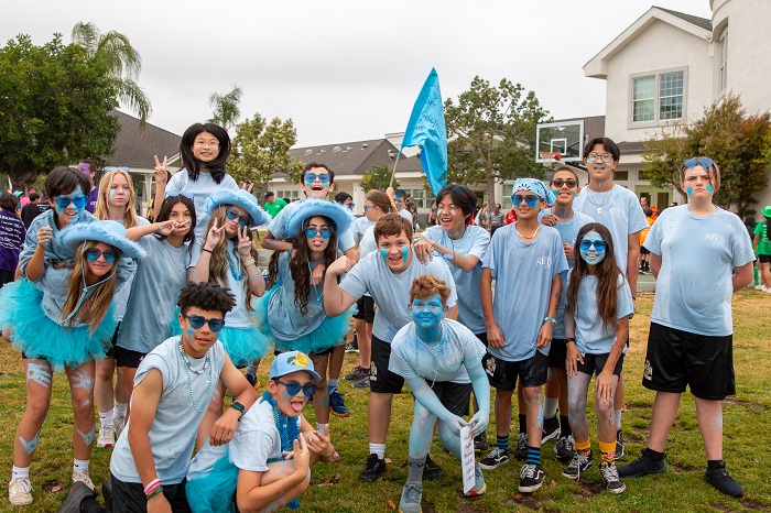 middle school class of students grouped together smiling dress in all blue