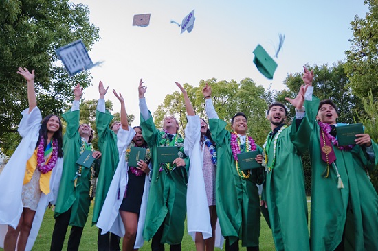 High School Graduating senior tossing graduation caps in the air