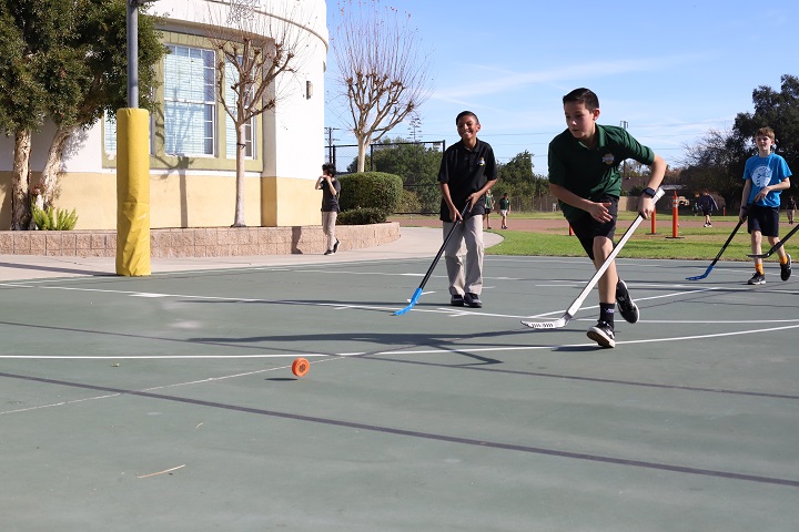 elementary school pe students playing hockey