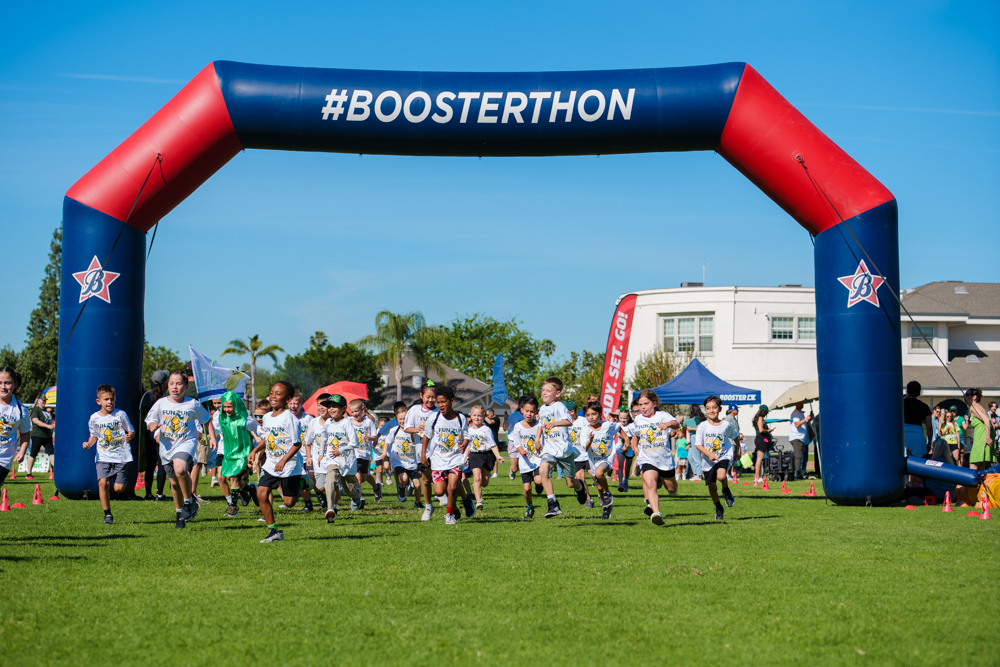 Three high school senior in their cap and gowns smiling at the crowd during the graduation ceremony.